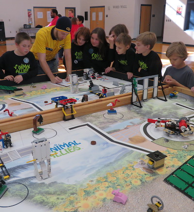 Students playing with robots at a FLL event
